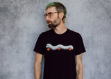 A model wearing a black t-shirt with a hand drawn illustration of a millipede in a ghost costume carrying jack'o lantern candy pails. 