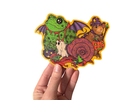 A hand holding a sticker featuring various animals trick or treating in retro style costumes for halloween. 