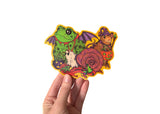 A hand holding a sticker featuring various animals trick or treating in retro style costumes for halloween. 
